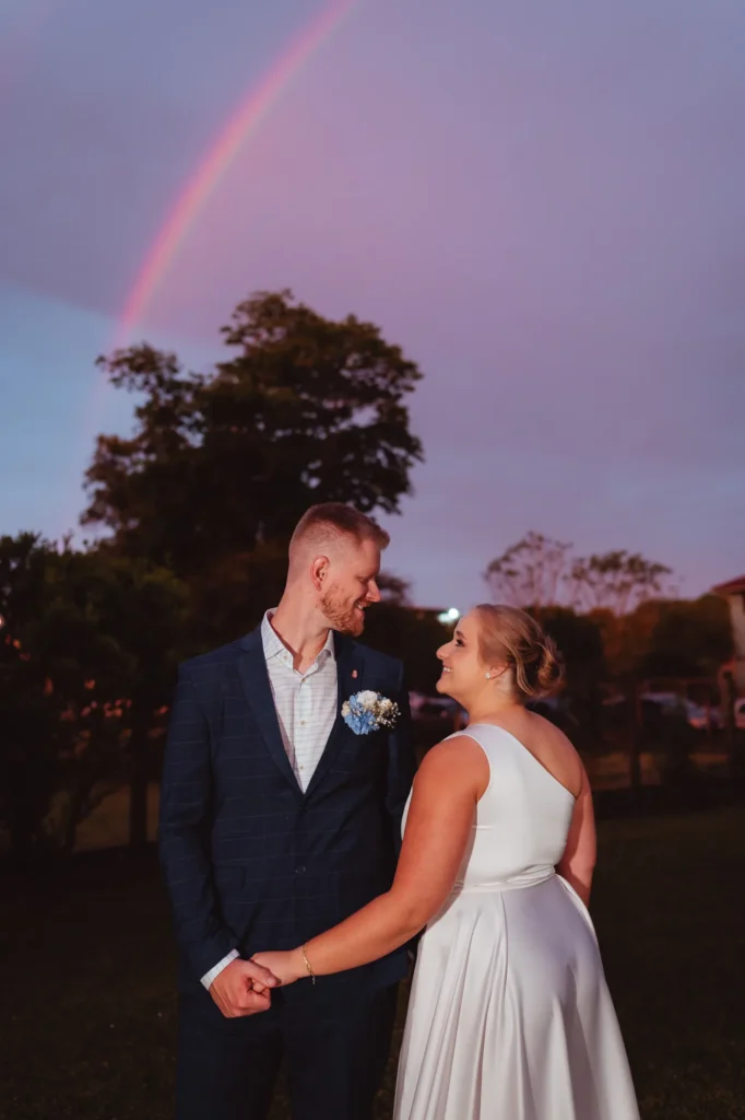 Ana e Fred ao entardecer, com um arco-íris no céu