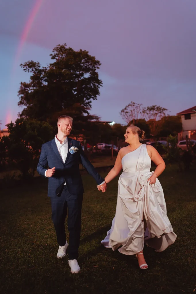 Ana e Fred caminhando no gramado ao entardecer