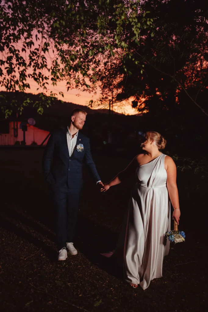 Ana e Fred caminham de mãos dadas no fim da tarde