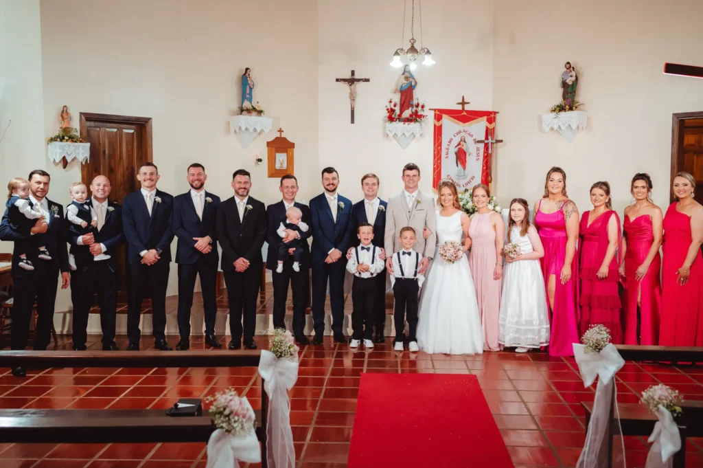 Bárbara e Mateus no altar, com padrinhos e madrinhas dos dois lados