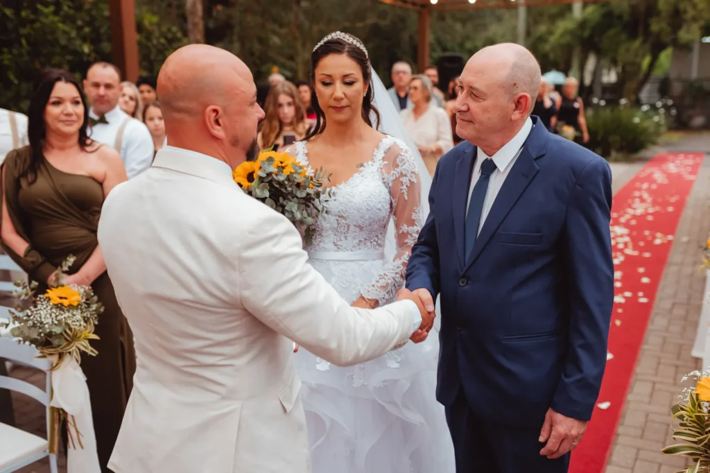Dionei cumprimenta o pai de Carla ao receber a noiva no altar