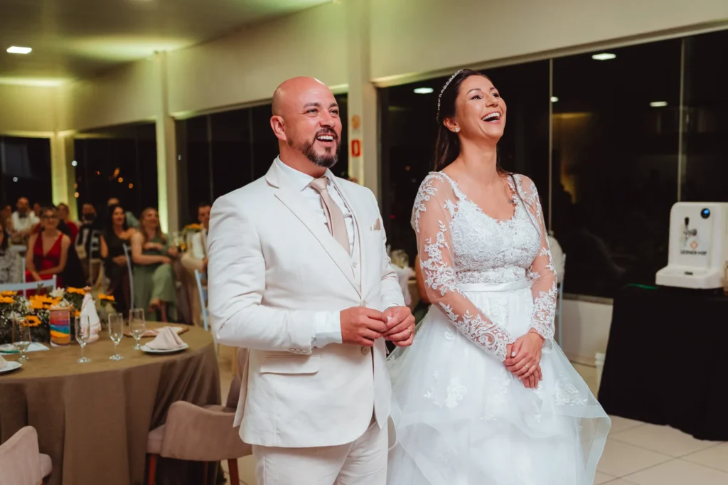 Carla e Dionei no salão da festa, entre as mesas dos convidados