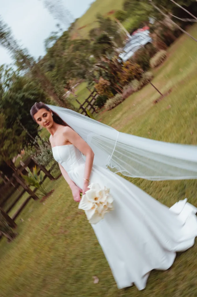Thais com o véu ao vento no jardim